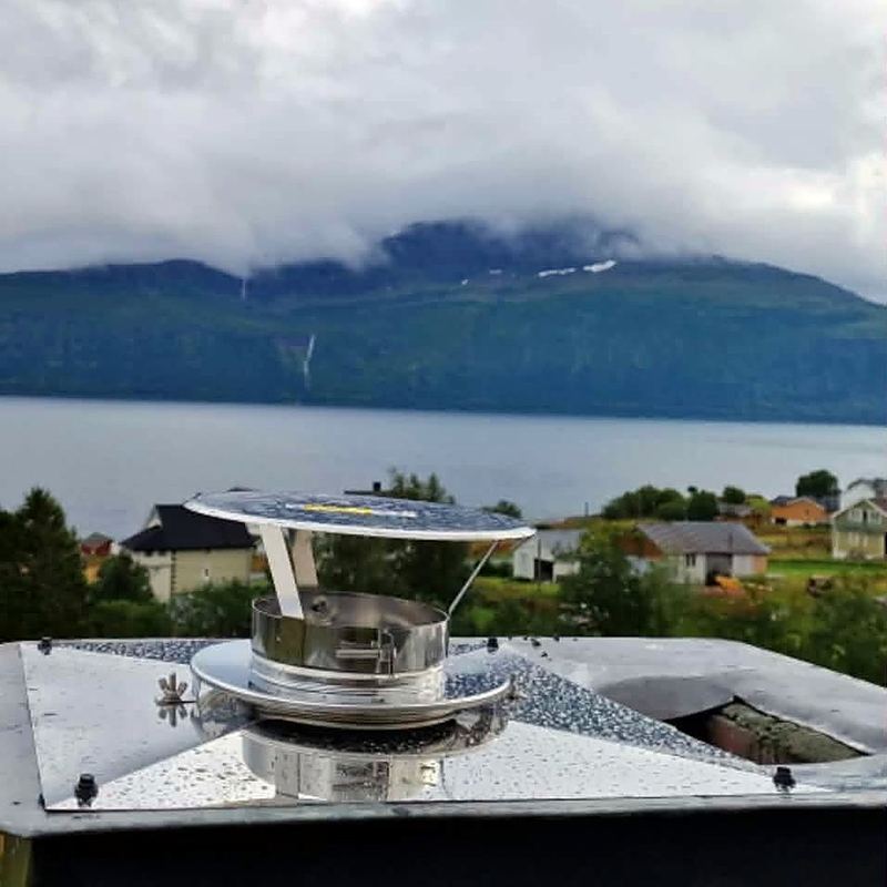 Ny regnhatt på pipa. Ferdig montert, med utsikt over fjorden.